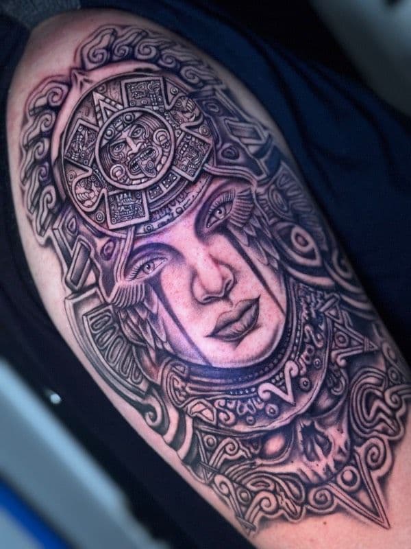 Black and grey ornamental Aztec warrior tattoo on upper arm