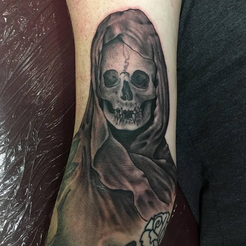 Black and grey realistic grim reaper skull on forearm