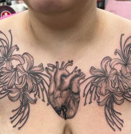 Black and grey realistic heart and lilies tattoo on chest